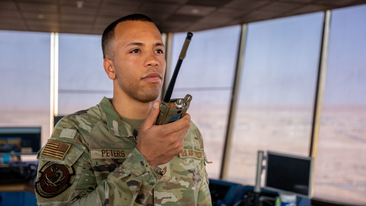 A man holds a radio near his mouth.