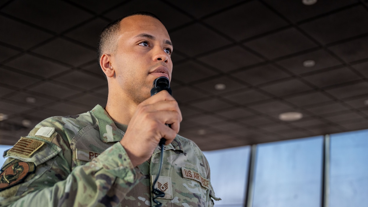 A man holds a radio microphone by his mouth.