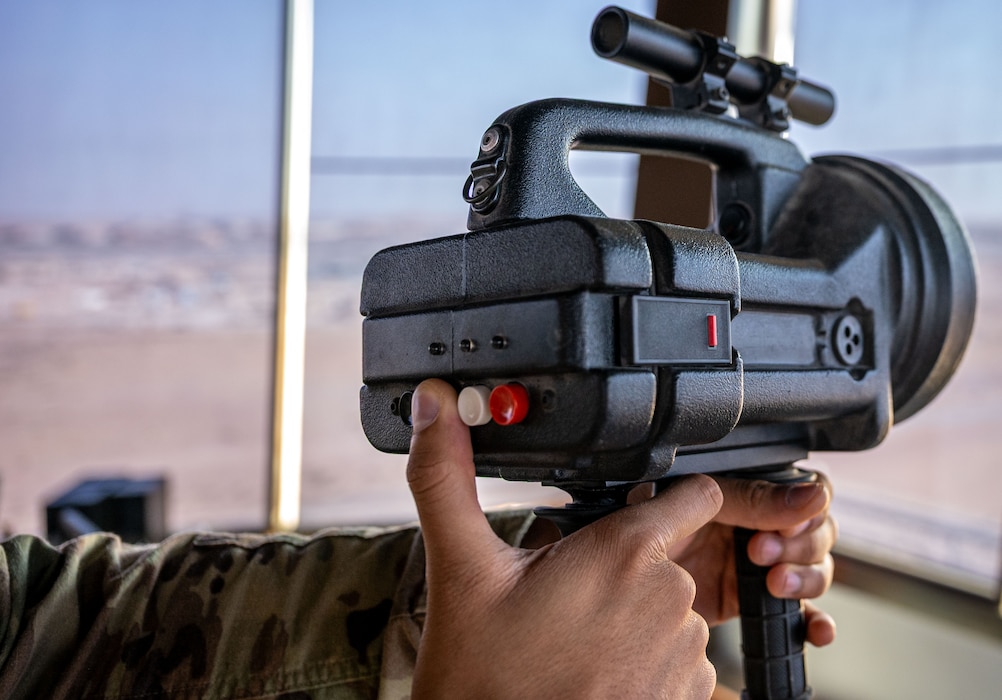 A finger pushes a button on a light gun.