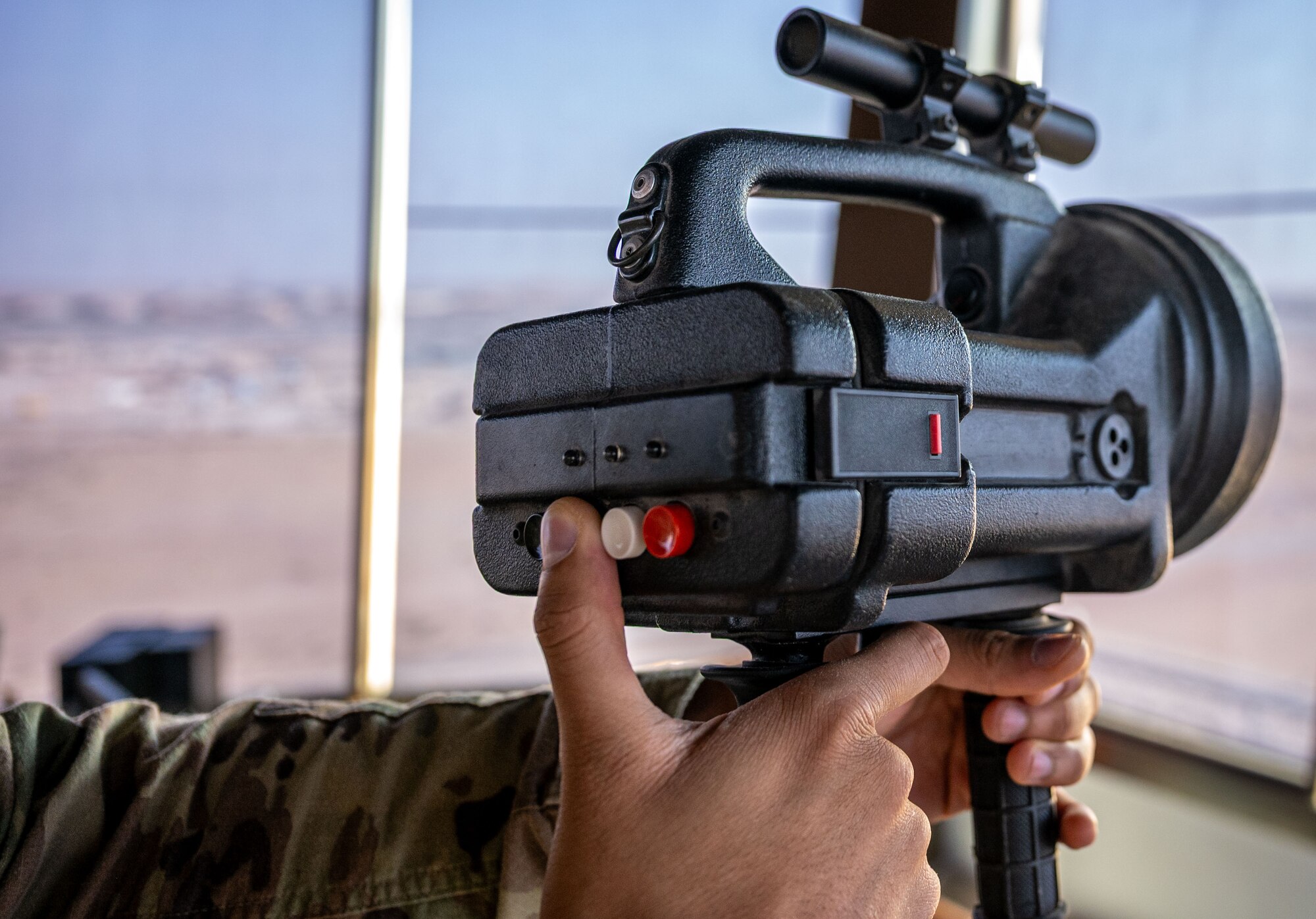 A finger pushes a button on a light gun.