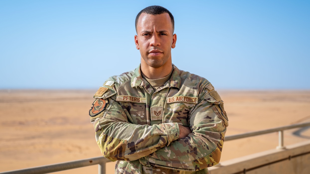 A man poses for a photo on the air traffic control tower.