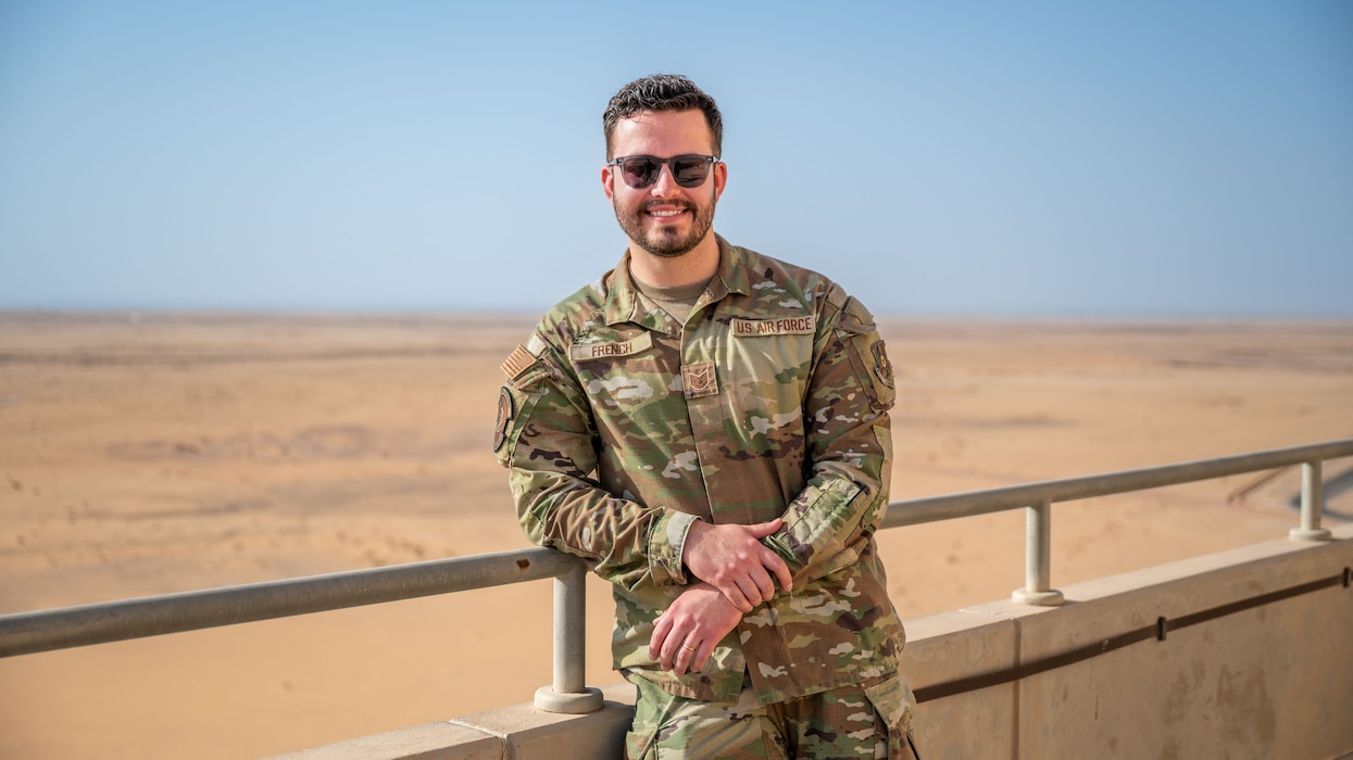 A man poses for a photo on the air traffic control tower.