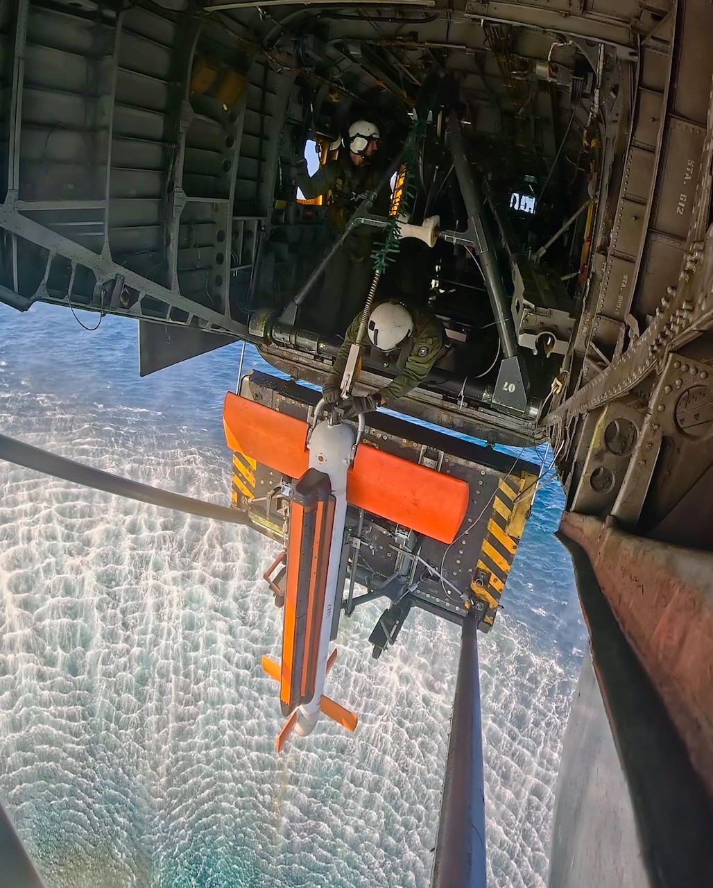 Naval Aircrewman Helicopter 2nd Class Alejandro Mojica and Naval Aircrewman Helicopter 3rd Class Joshua Palmer work to stream the AN/AQS-24C mine countermeasures sonar from an MH-53E Sea Dragon helicopter during Multinational Mine Warfare Exercise (MNMIWEX) 25 near Busan, South Korea, Oct. 27, 2025.