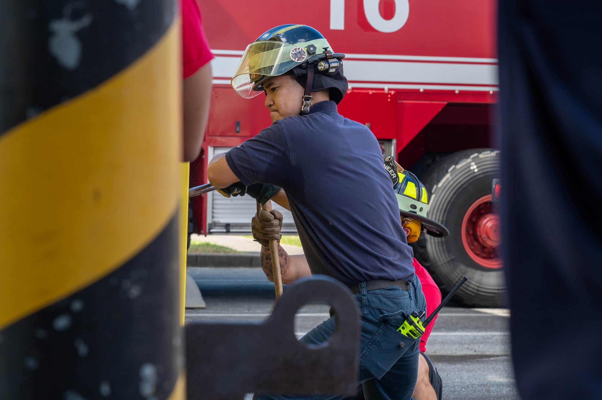 Tametoki Ota, 18th Civil Engineer Squadron firefighter, demonstrates a forcible entry during an open house.
