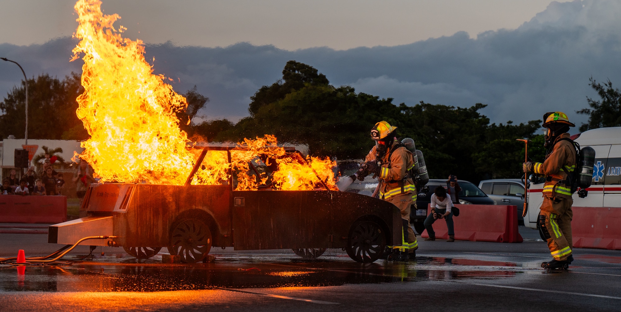 U.S. Air Force firefighters assigned to the 18th Civil Engineer Squadron fight a simulated car fire during a Fire Prevention Week demonstration.