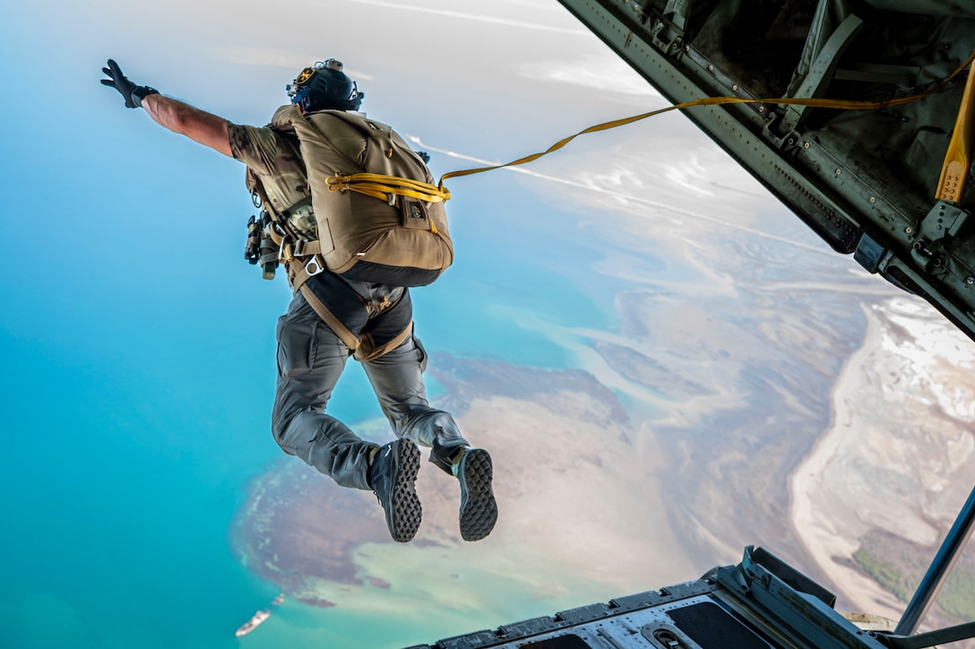 A U.S. Air Force pararescueman assigned to the 82nd Expeditionary Rescue Squadron  leaps from a U.S. Marine Corps KC-130J Hercules cargo aircraft.