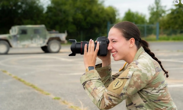 Spc. Josephine Malloy, mass communications specialist for the 114th Public Affairs Detachment, takes a photo during Saber Junction 25 at the Hohenfels Training Area, Joint Multinational Readiness Center, Germany on Sept. 9, 2025. For its annual training, the PAD provided public affairs support to Saber Junction, a multinational military exercise involving more than 7,600 participants from 15 allied and partner nations. Photo by Sgt. Christian Aquino, JMRC.
