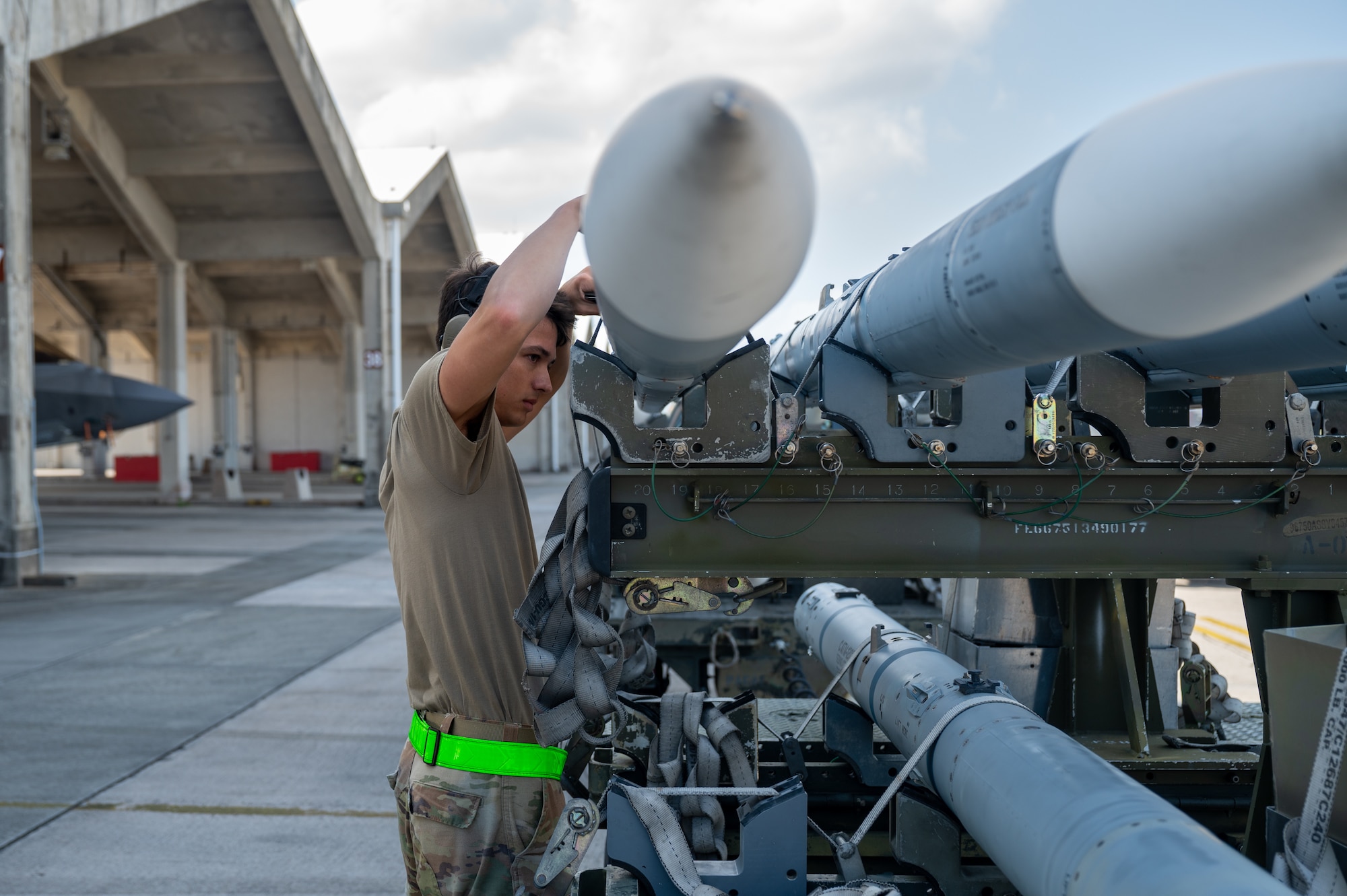 U.S. Air Force Airmen load munitions onto aircraft.