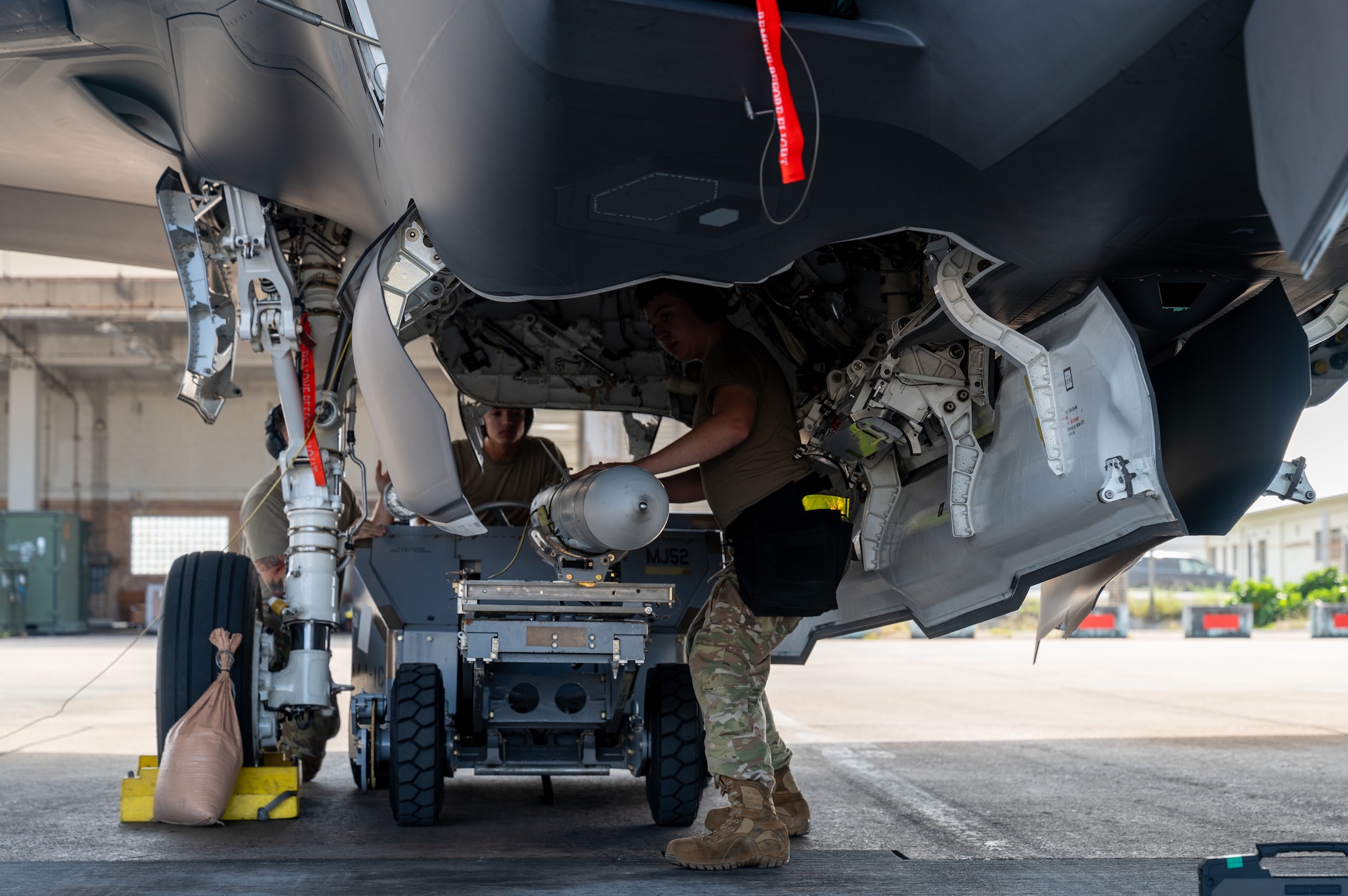 U.S. Air Force Airmen load munitions onto aircraft.