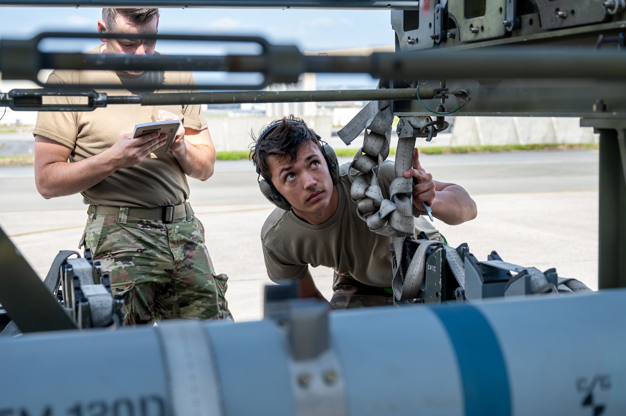 U.S. Air Force Airmen load munitions onto aircraft.