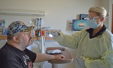 251024-N-ME175-1001 JACKSONVILLE, Fla. (Oct. 24, 2025) – Ens. Elizabeth Barber, a Multi-Service Unit nurse, performs a pupil reaction test on Scott Korschewitz, a Department of Veteran Affairs (VA) patient at Naval Hospital Jacksonville Oct. 24. onboard Naval Air Station Jacksonville. VA patients are being seen in many departments such as the Emergency Department, Orthopedics, and the Substance Abuse Rehabilitation Program. (U.S. Navy photo by Julie M. Lucas, Naval Hospital Jacksonville/Released)