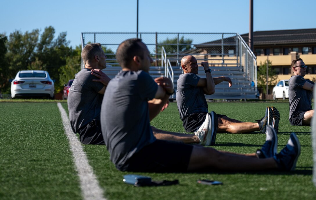 Chief Master Sgt. of the Space Force John Bentivegna and Guardians assigned to Space Delta 13, stretch after physical training at Joint Base Andrews, Maryland.
