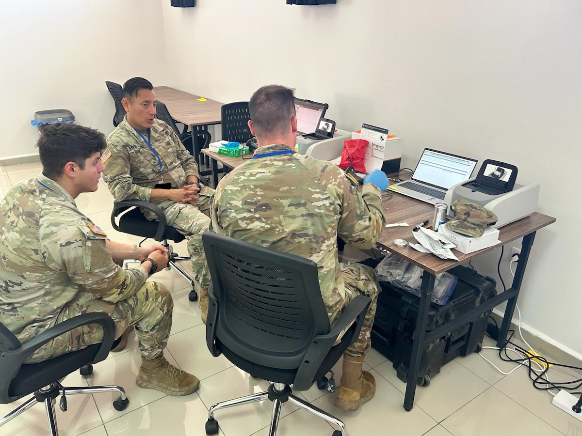 MAJ Pow Sang (middle), Chief of Microbiology at WRAIR-Africa, teaches soldiers how to use BioFire equipment for disease surveillance at African Lion 2025.