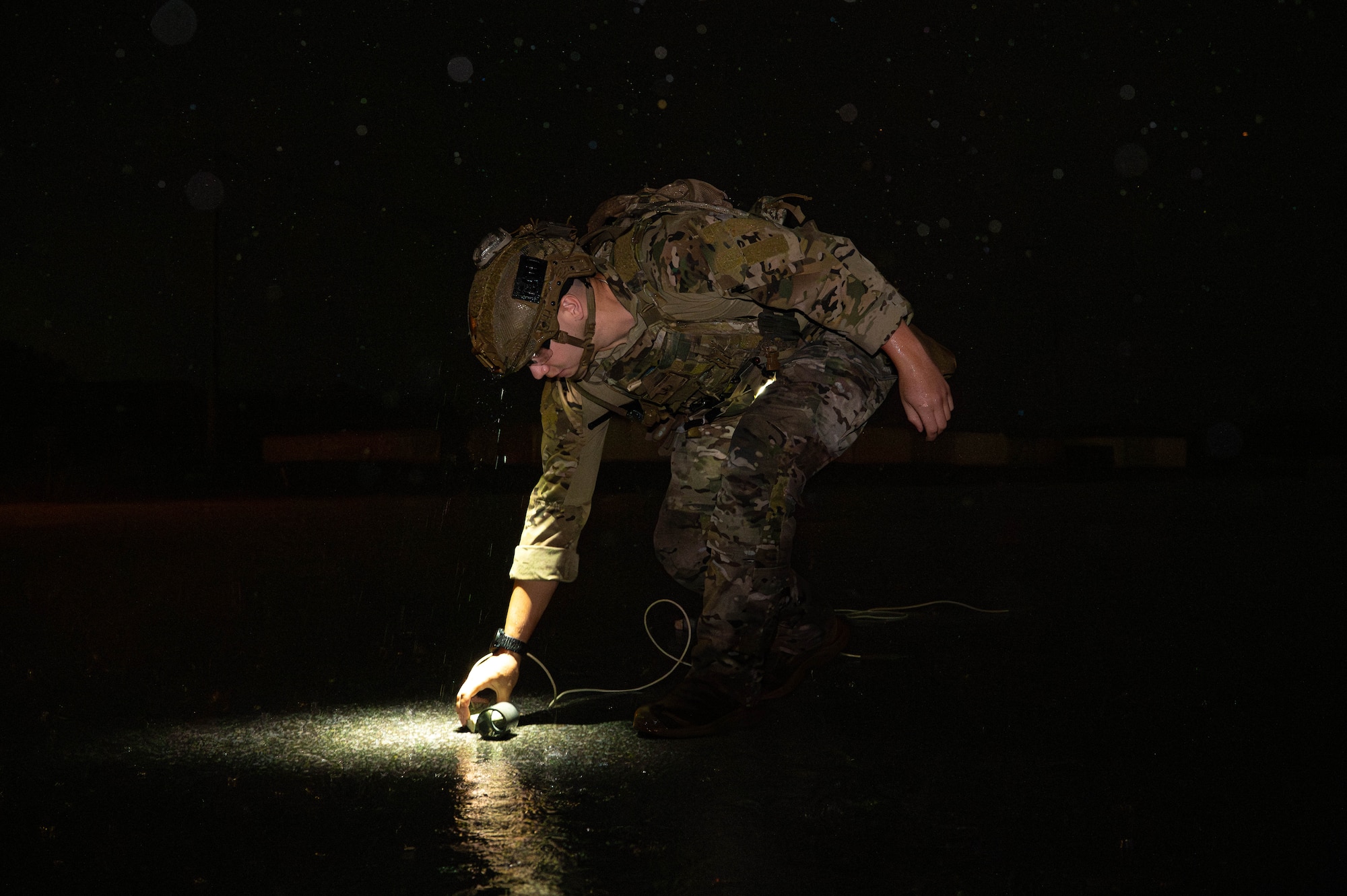 U.S. Air Force Senior Airman Cody Fain, 18th Civil Engineer Squadron explosive ordinance disposal team member,  places C-4 on simulated unexploded ordnance during a mass mechanical clearance exercise in support of BH 26-1 at Kadena Air Base, Japan, Nov. 4, 2025. The exercise focused on rapidly removing submunitions from the runway to return the airfield to full operational capability. (U.S. Air Force photo by Airman Nathaniel Jackson)