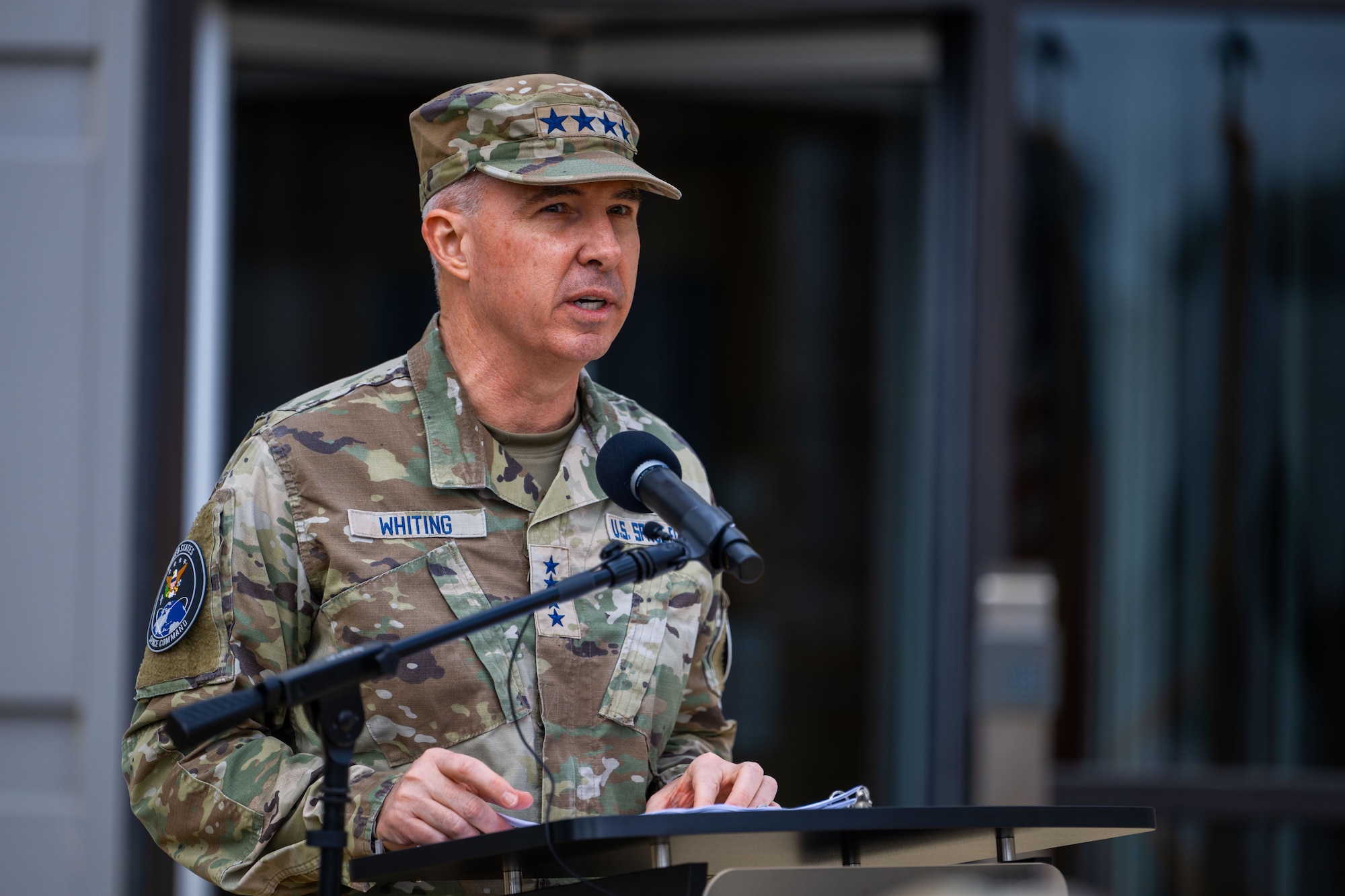 A military general speaks at a podium.