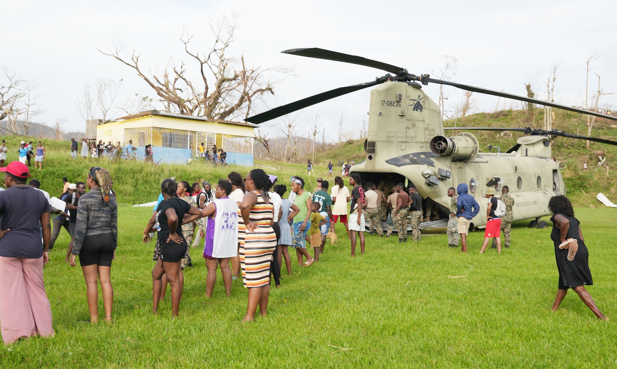 People line up in front of a military helicopter