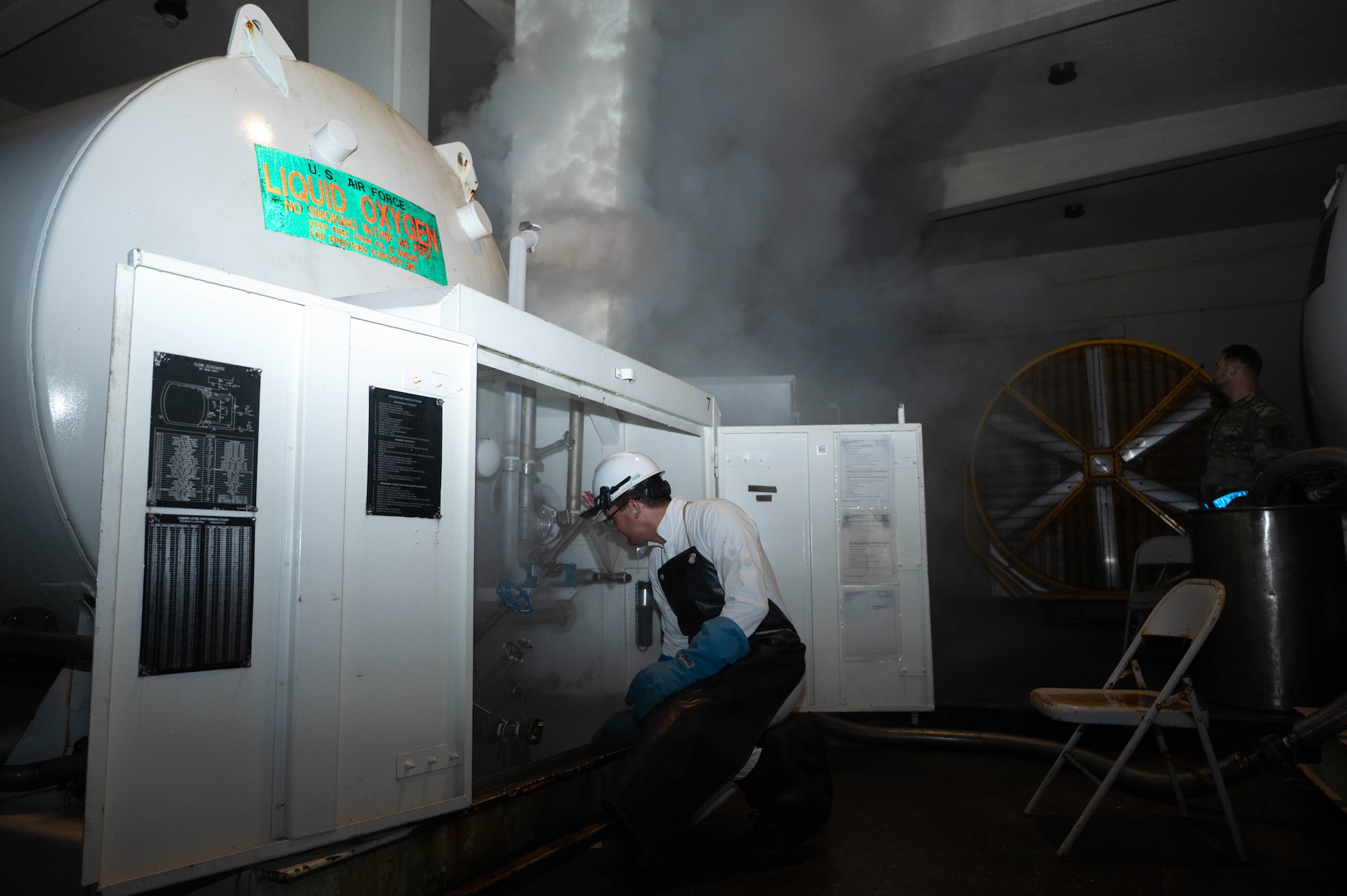 An airmen performs a standard maintenance check on a liquid oxygen tank.