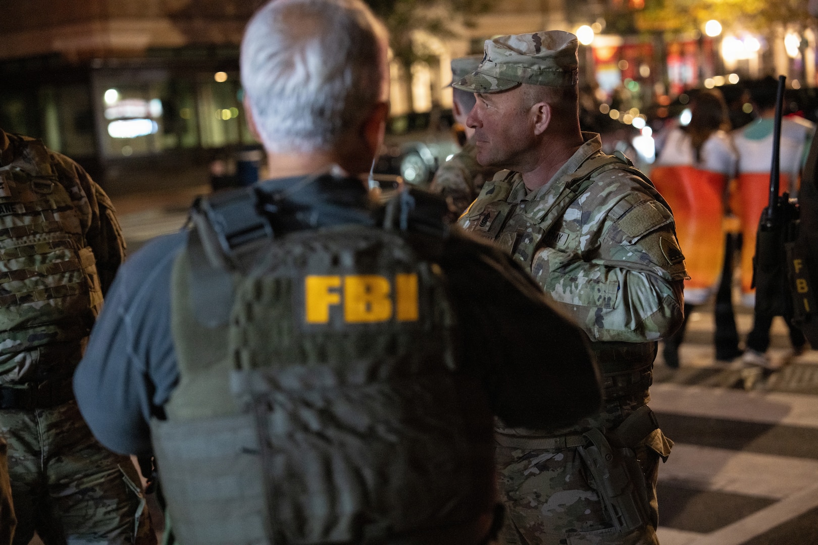 U.S. Army Command Sgt. Maj. Scott McKennon, right, Joint Task Force–District of Columbia senior enlisted leader, D.C. National Guard, coordinates with civilian law enforcement in Washington, D.C., Oct. 31, 2025. About 2,400 National Guard members support the D.C. Safe and Beautiful mission, assisting the Metropolitan Police Department in maintaining public safety for residents, commuters and visitors throughout the District.