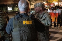 U.S. Army Command Sgt. Maj. Scott McKennon, right, Joint Task Force–District of Columbia senior enlisted leader, D.C. National Guard, coordinates with civilian law enforcement in Washington, D.C., Oct. 31, 2025. About 2,400 National Guard members support the D.C. Safe and Beautiful mission, assisting the Metropolitan Police Department in maintaining public safety for residents, commuters and visitors throughout the District.