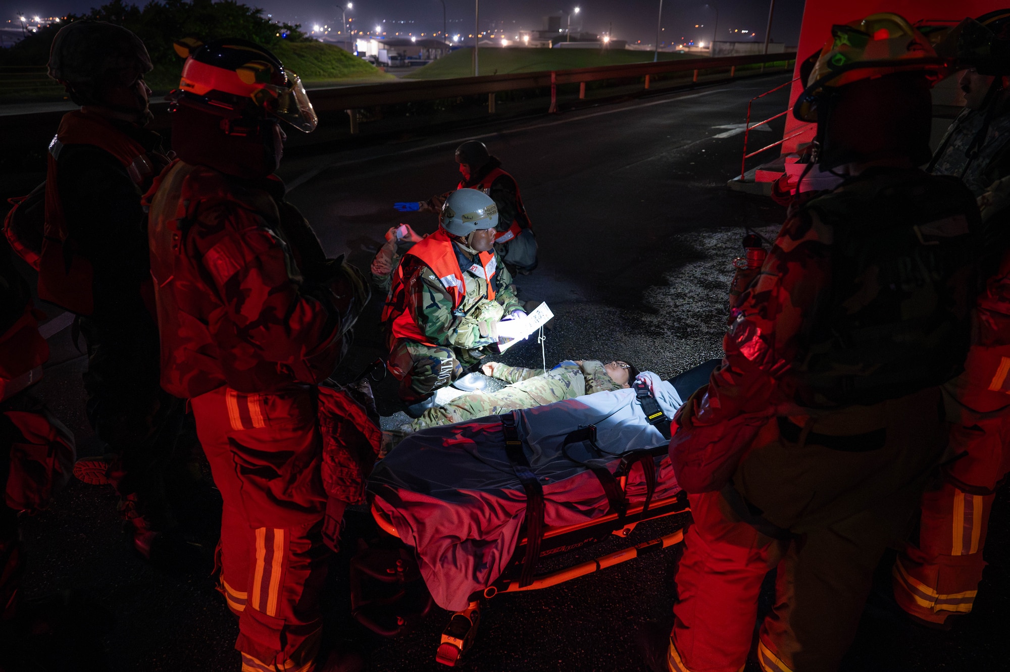 U.S. Air Force Airmen assigned to the 18th Civil Engineer Squadron and 18th Operational Medical Readiness Squadron provide  medical care to simulated injured personnel from the 18th Comptroller Squadron during a mass casualty exercise in support of base-wide operational readiness exercise BH 26-1 at Kadena Air Base, Japan, Nov. 6, 2025. Once fire crews cleared the area of possible unexploded ordnance, the medical response team performed tactical combat casualty care, treating simulated blast and burn victims and coordinating medical transport as needed. (U.S. Air Force photo by Airman Nathaniel Jackson)