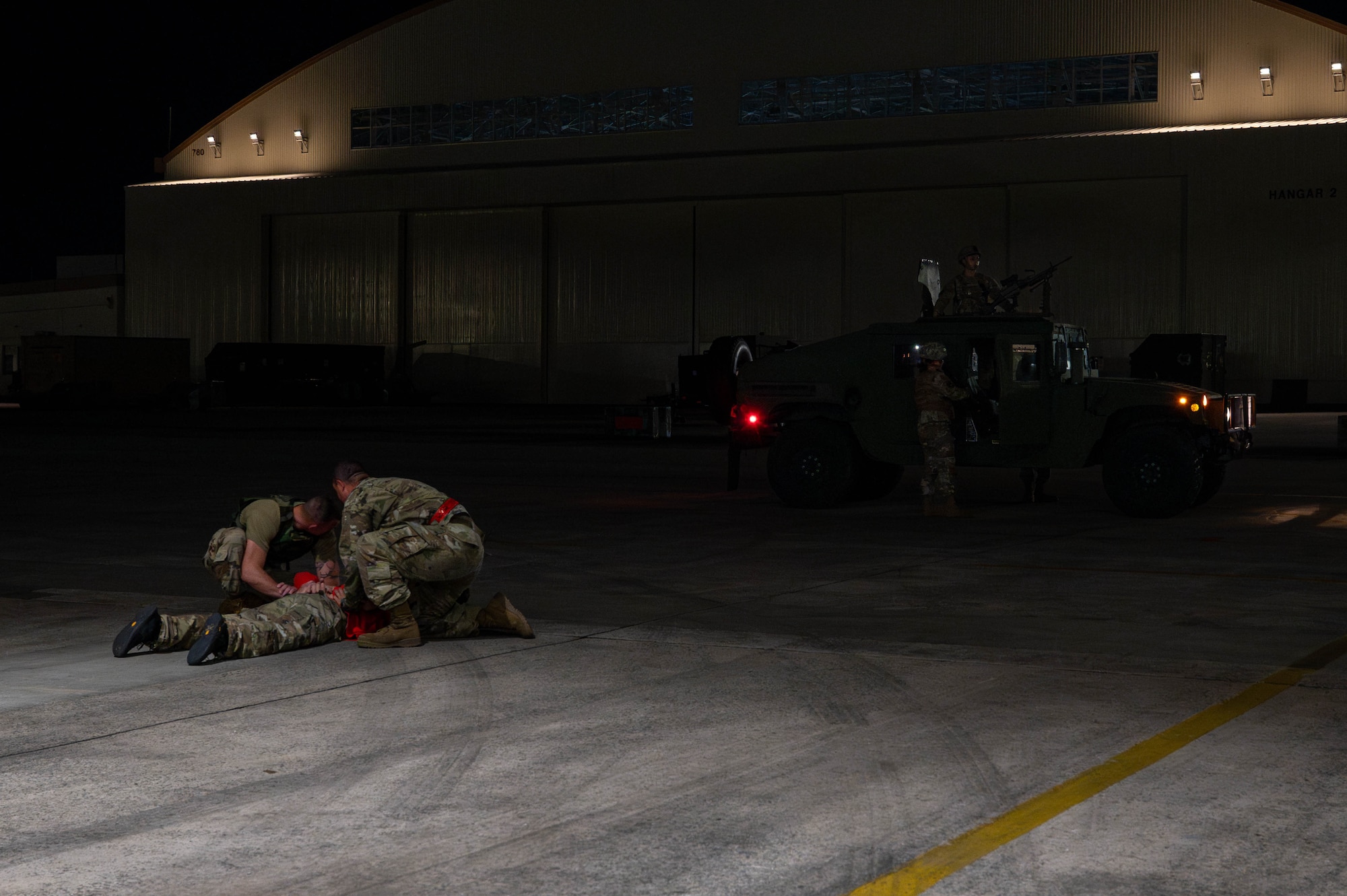 Two U.S. Air Force Airmen assigned to the 119th Expeditionary Fighter Generation Squadron detain a simulated intruder while awaiting the arrival of 18th Security Forces Squadron responders during base-wide operational readiness exercise, BH 26-1 at Kadena Air Base, Japan, Nov. 6, 2025. The exercise tested Airmen’s ability to respond to security threats and maintain control of restricted areas. (U.S. Air Force photo by Airman Nathaniel Jackson)