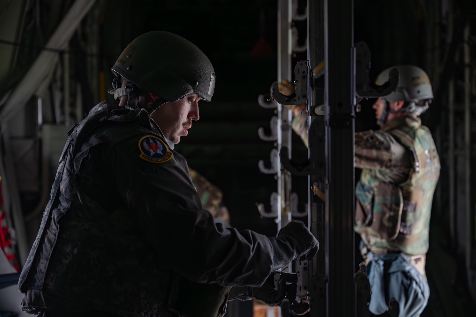 A service member sets up posts to support patient gurneys.
