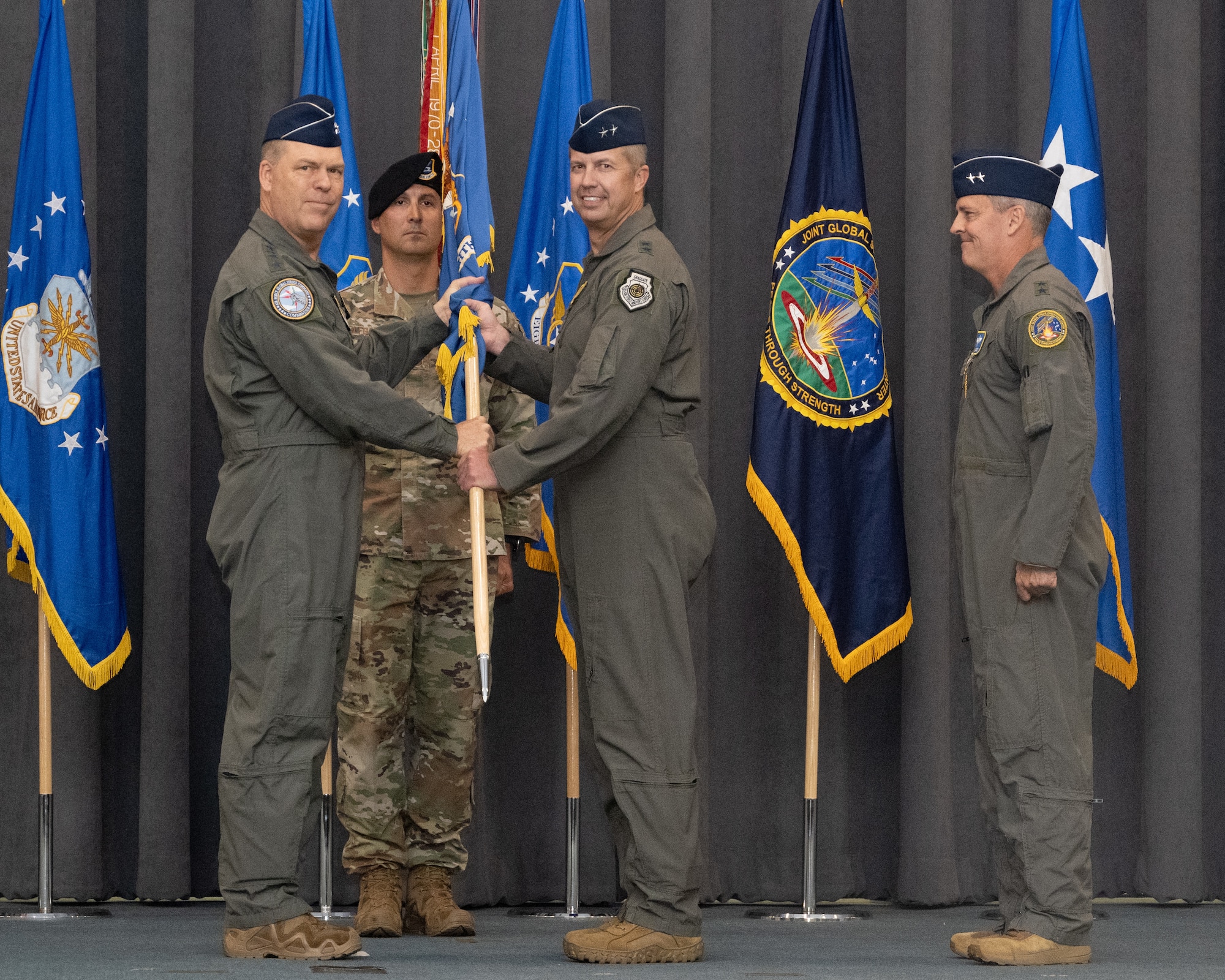 Gen. S.L. Davis, left, commander of Air Force Global Strike Command, passes the Eighth Air Force guidon to Maj. Gen. Ty Neuman