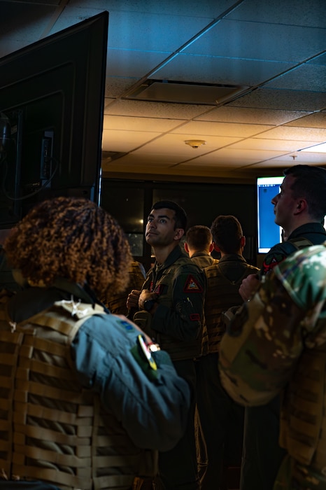 An air crew watching a PowerPoint.