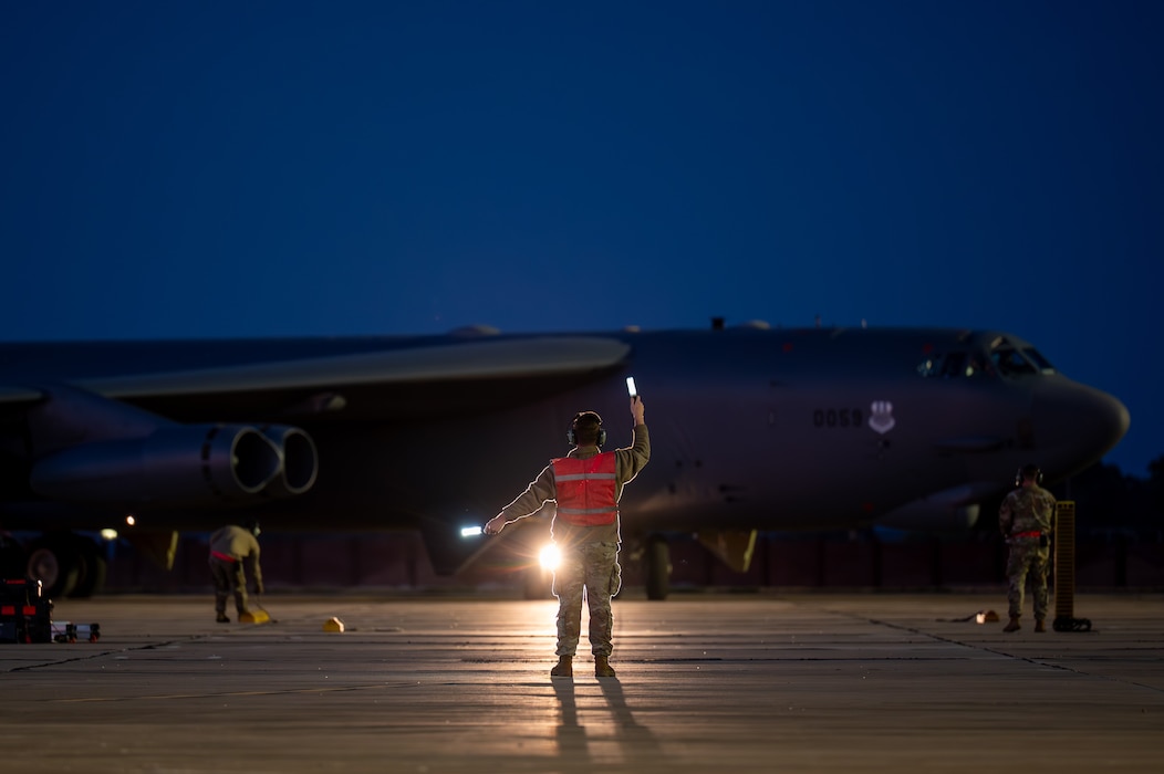 A man guides aircraft to park.