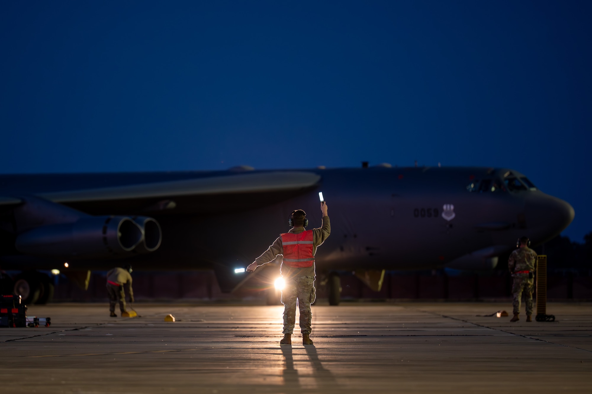 A man guides aircraft to park.