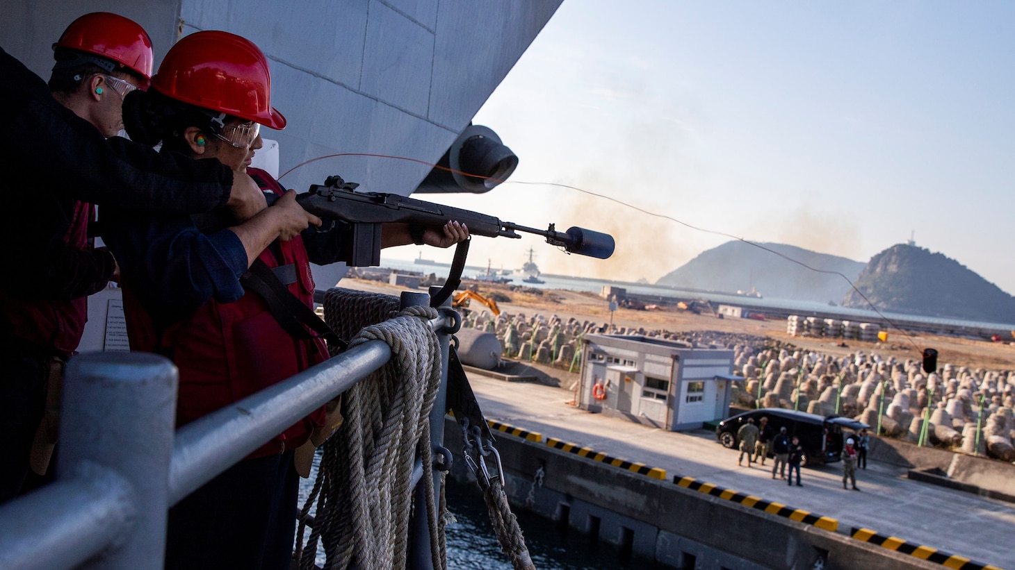 Gunner’s Mate Seaman Georgia Martinezrios, from Florida, assigned to weapons department, shoots a shot line from the fantail during a sea-and-anchor evolution aboard Nimitz-class aircraft carrier USS George Washington (CVN 73) while pulling into Busan, Republic of Korea, Nov. 5, 2025.