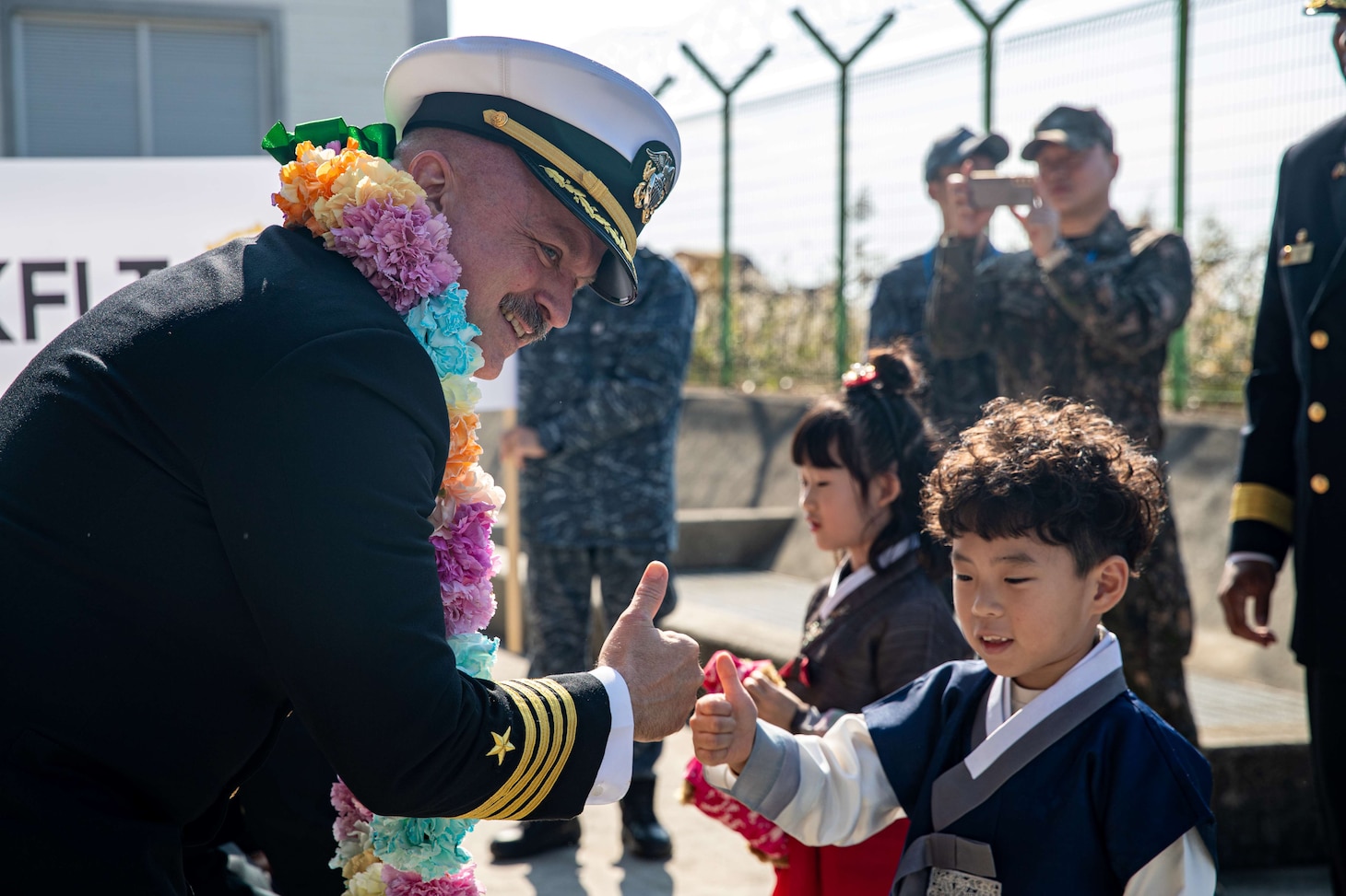Capt. Timothy Waits, commanding officer of Nimitz-class aircraft carrier USS George Washington (CVN 73), poses for a photo with a Korean child during a welcoming ceremony at Busan Naval Base, Busan, Republic of Korea, Nov. 5, 2025.