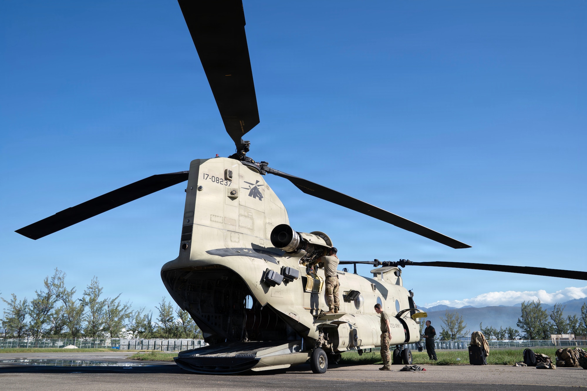 people stand around a helicopter