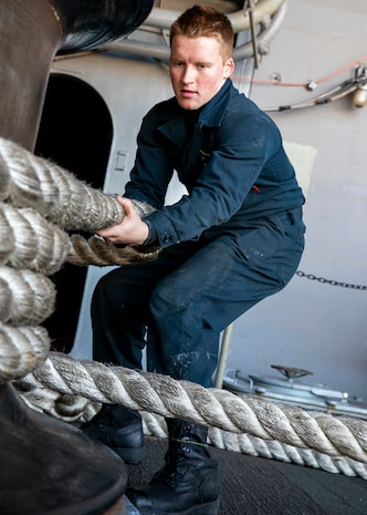 Boatswain’s Mate Seaman Christian Richter, from Pennsylvania, assigned to deck department, heaves a mooring line around a capstan on the fantail during a sea-and-anchor evolution aboard Nimitz-class aircraft carrier USS George Washington (CVN 73) while pulling into Busan, Republic of Korea, Nov. 5, 2025.