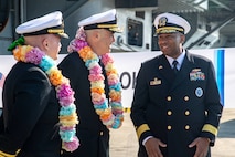 Rear Adm. Eric Anduze, center, commander, Carrier Strike Group 5, and Capt. Timothy Waits, commanding officer of Nimitz-class aircraft carrier USS George Washington (CVN 73), speak to Rear Adm. Sharif H. Calfee, Commander, U.S. Naval Forces Korea, during a welcoming ceremony at Busan Naval Base, Busan, Republic of Korea, Nov. 5, 2025.
