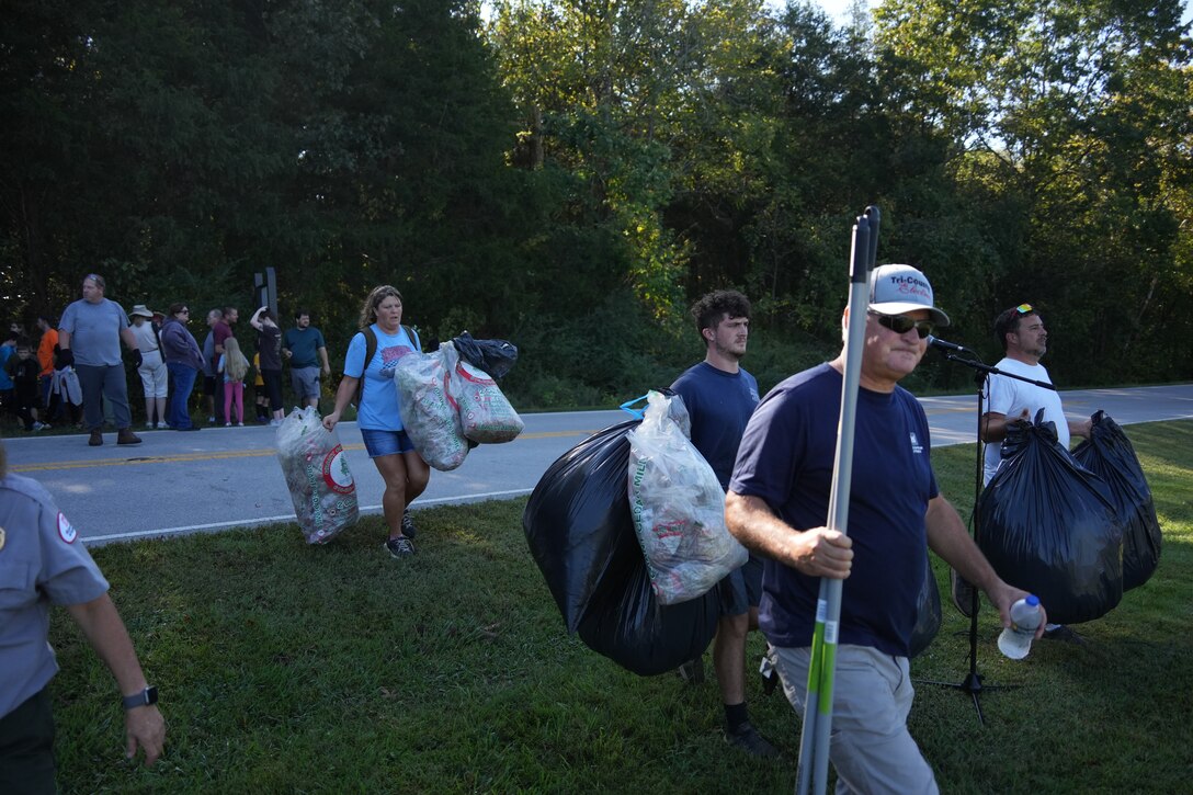 Volunteers haul trash bags after cleaning and applying a half-mile of mulch to the Periwinkle Trail at Cordell Hull Lake, transforming the area into a new Storybook Trail in Granville, Tennessee, Sept. 27, 2025.