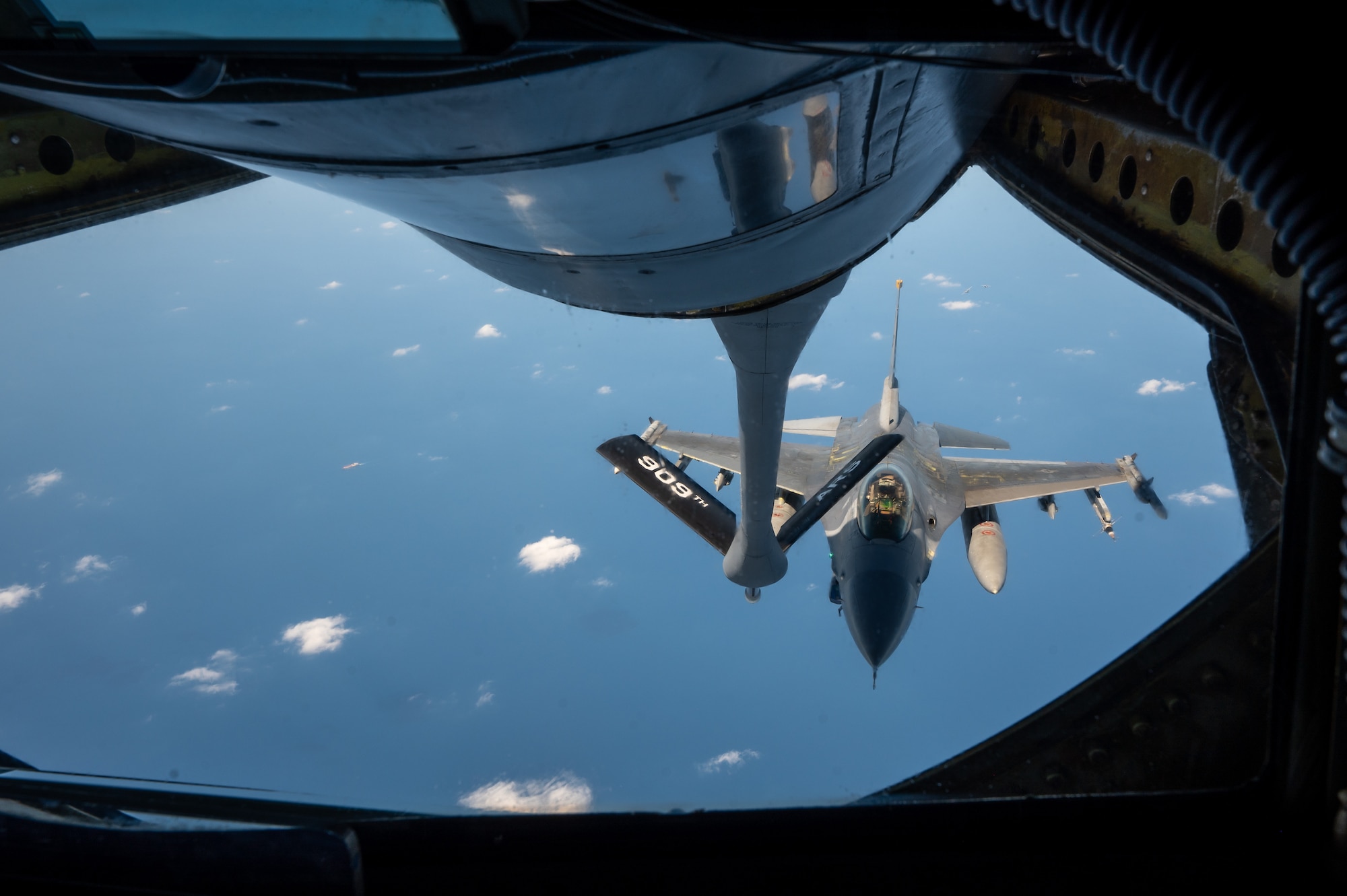 aircraft flies towards the boom pod window for refueling