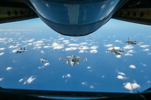 a front view of a formation of five fighters from a boom pod window
