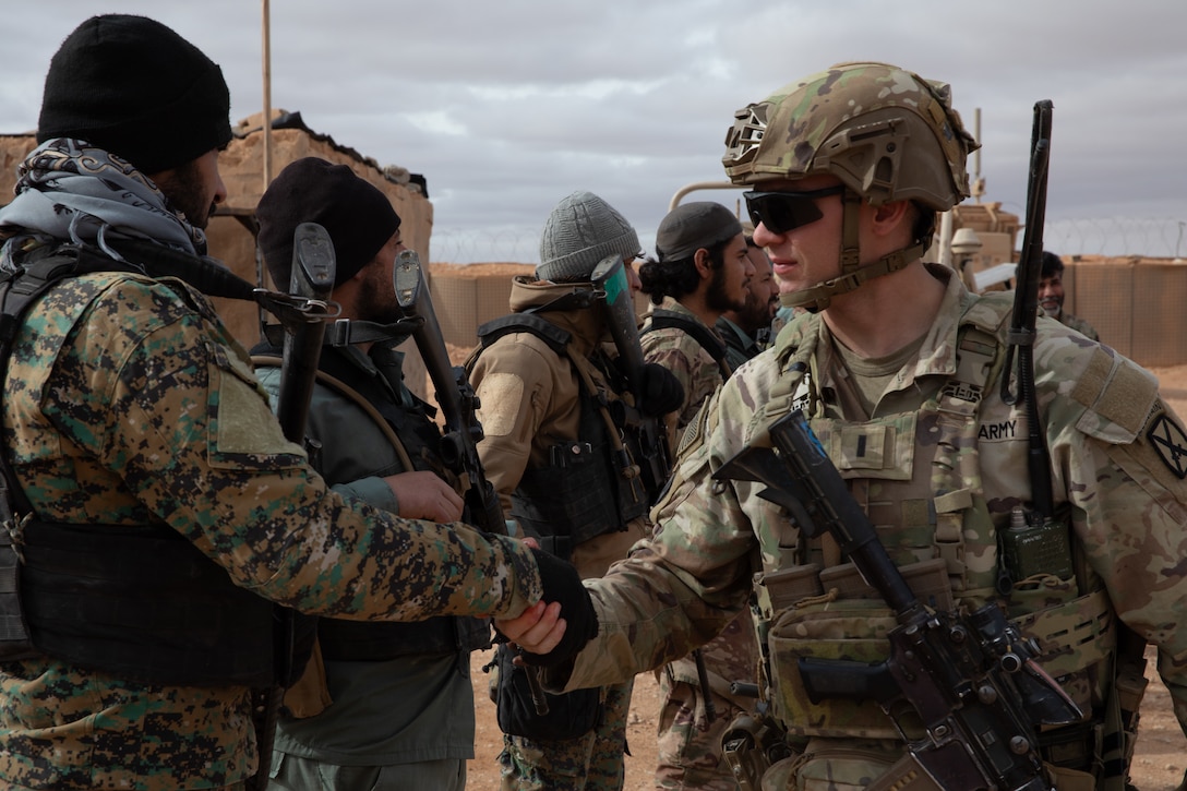 A U.S. Army Soldier, assigned to 4th Platoon, Alpha Company, 1st Battalion, 32nd Infantry Regiment, 1st Brigade Combat Team, 10th Mountain Division, Task Force Armadillo, greets a Syrian Free Army (SFA) soldier during a patrol in the Deconfliction Zone at Al-Tanf, Syria, on Dec. 28, 2024. The Coalition advises, assists and supports partner forces to ensure the lasting defeat of ISIS and radical extremist ideologies. The Coalition will also continue working with the SFA to enable the safety and security of civilians and partner forces. (U.S. Army photo by Sgt. Trenton Pallone)