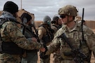 A U.S. Army Soldier, assigned to 4th Platoon, Alpha Company, 1st Battalion, 32nd Infantry Regiment, 1st Brigade Combat Team, 10th Mountain Division, Task Force Armadillo, greets a Syrian Free Army (SFA) soldier during a patrol in the Deconfliction Zone at Al-Tanf, Syria, on Dec. 28, 2024. The Coalition advises, assists and supports partner forces to ensure the lasting defeat of ISIS and radical extremist ideologies. The Coalition will also continue working with the SFA to enable the safety and security of civilians and partner forces. (U.S. Army photo by Sgt. Trenton Pallone)
