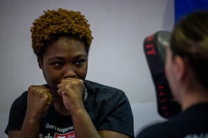 An attendee holds their fist in front of their face during a self-defense basics course.