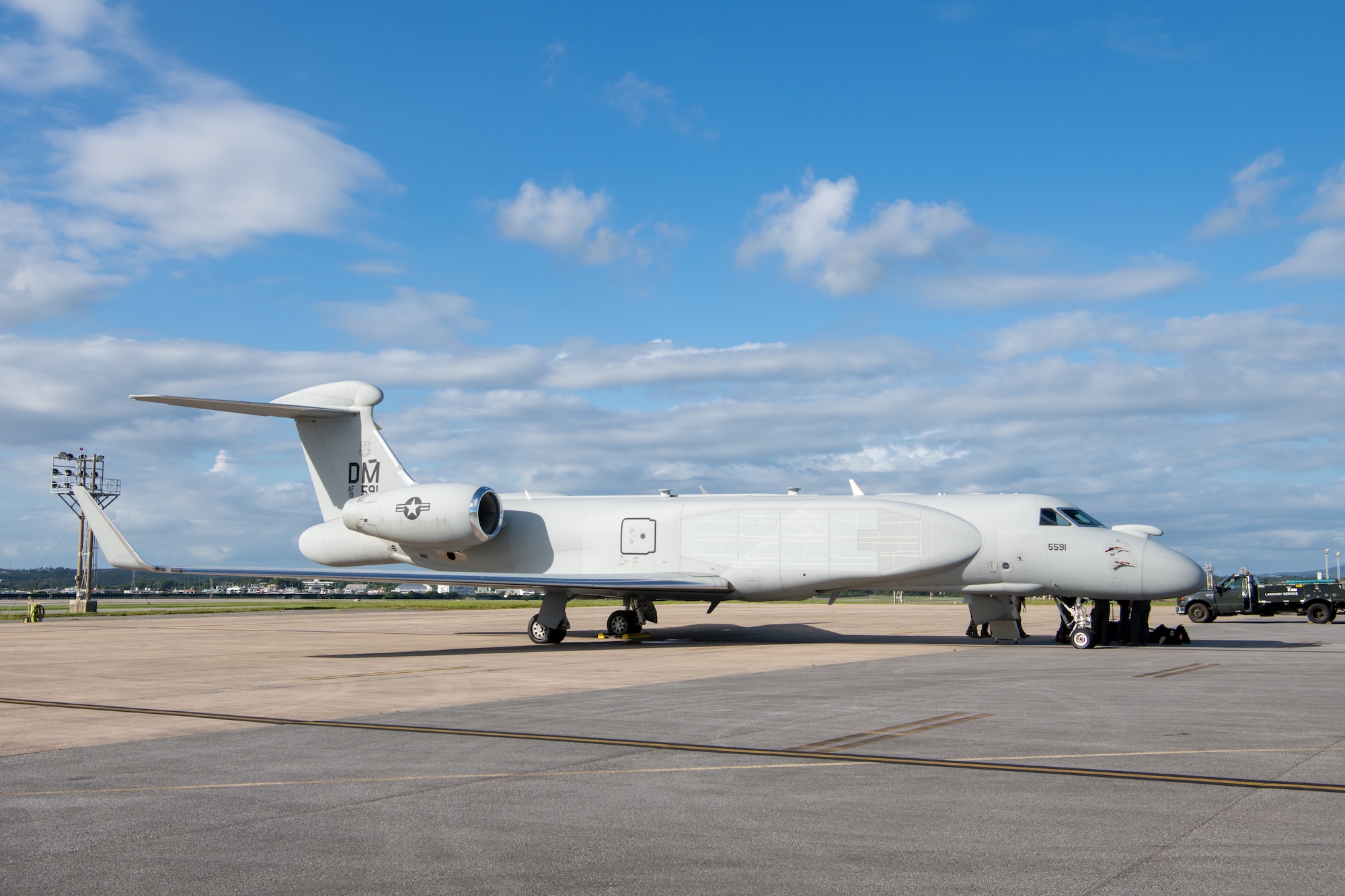 The right side view of a white aircraft sits on the flightline