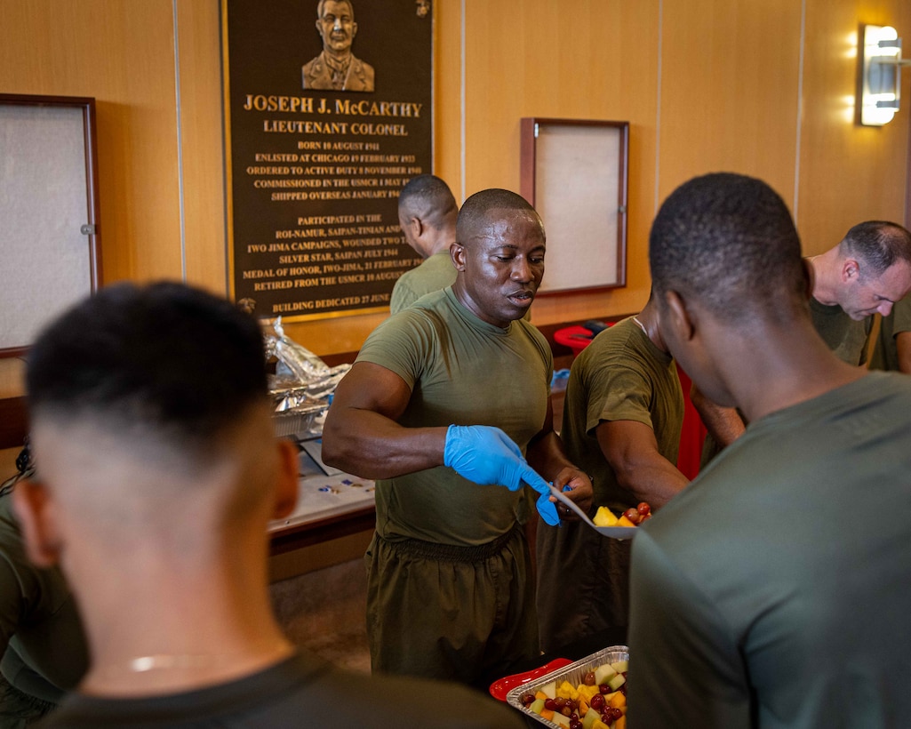 U.S. Marine Corps Sgt. Maj. Kabiru Labaran, sergeant major, Headquarters Battalion, Marine Forces Reserve, serves food during a warrior’s breakfast after an annual birthday motivational run celebrating the 250th birthday of U.S. Marine Corps, in New Orleans, Nov. 7, 2025. The run started at the Marine Corps Support Facility New Orleans and traveled along the Mississippi River ending back at MCSF. The run celebrates the history of the Marine Corps and creates esprit de corps and comradery among Marines. (U.S. Marine Corps photo by Lance Cpl. Juan Diaz)