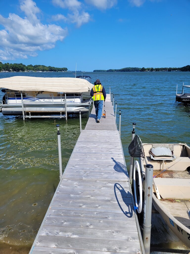 A member of the U.S. Army Corps of Engineers, Buffalo District Regulatory Branch team performs a compliance inspection of a dock and associated structures on Sodus Bay in Sodus Point, N.Y.