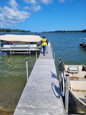 A member of the U.S. Army Corps of Engineers, Buffalo District Regulatory Branch team performs a compliance inspection of a dock and associated structures on Sodus Bay in Sodus Point, N.Y.