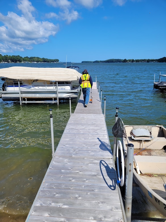 A member of the U.S. Army Corps of Engineers, Buffalo District Regulatory Branch team performs a compliance inspection of a dock and associated structures on Sodus Bay in Sodus Point, N.Y.