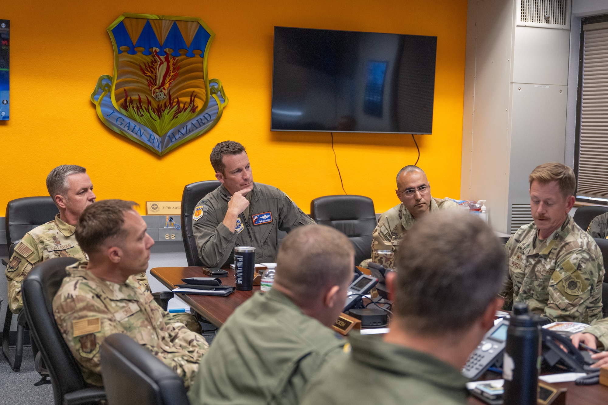 Airmen sit around a conference table
