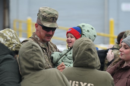 A Soldier assigned to the 152nd Engineer Support Company, 204th Engineer Battalion, 153rd Troop Command Brigade, 53rd Troop Command, New York Army National Guard, holds his child and is welcomed home by his family on Veterans Day from a deployment to East Africa on Nov. 11, 2025, in Cheektowaga, N.Y.