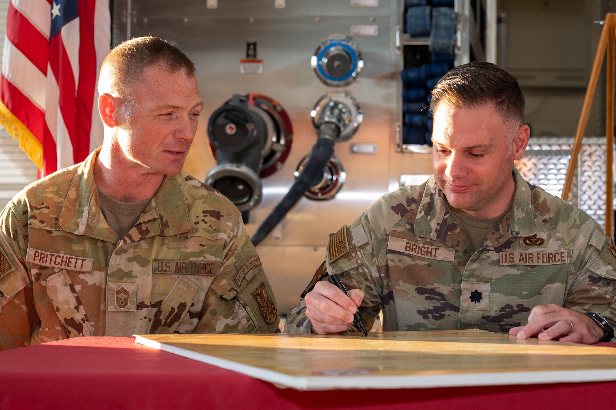 U.S. Air Force Lt. Col. Jacob Bright, 7th Civil Engineer Squadron commander, and Chief Master Sgt. William Pritchett, 7th CES fire chief, sign the 2025 Fire Prevention Week proclamation at Dyess Air Force Base, Texas, Oct. 2, 2025. The proclamation emphasizes the installation’s commitment to educating Airmen and families on preventive fire safety measures. (U.S. Air Force photo by Airman William Neal)