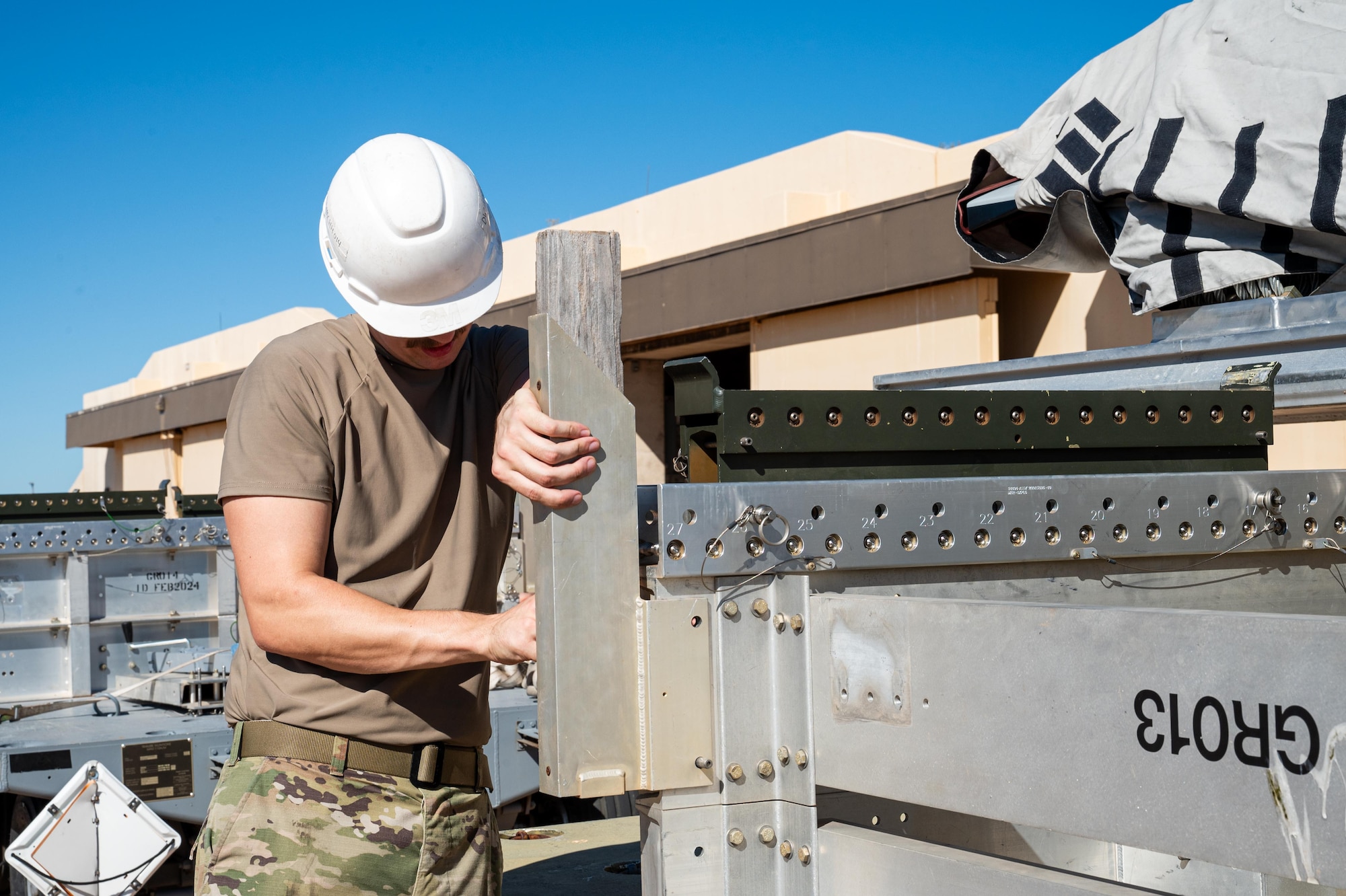 U.S. Air Force Senior Airman Daniel McNulty, 7th Munitions Squadron conventional maintenance crew chief, fastens stoppers on a trailer during exercise Death Strike 25-03 at Dyess Air Force Base, Texas, Sept. 22, 2025. The 7th MUNS tasked itself with rapidly moving its entire JASSM stockpile as part of contingency training during the exercise. (U.S. Air Force photo by Airman 1st Class Adrien Tran)
